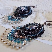 BO Angelot brodées avec des cabochons ovales en résine Noire, perles rondes nacrées Cristal et toupies. S’ajoute des facettes et rocailles. Le tout est monté sur des dormeuses Lys en Laiton